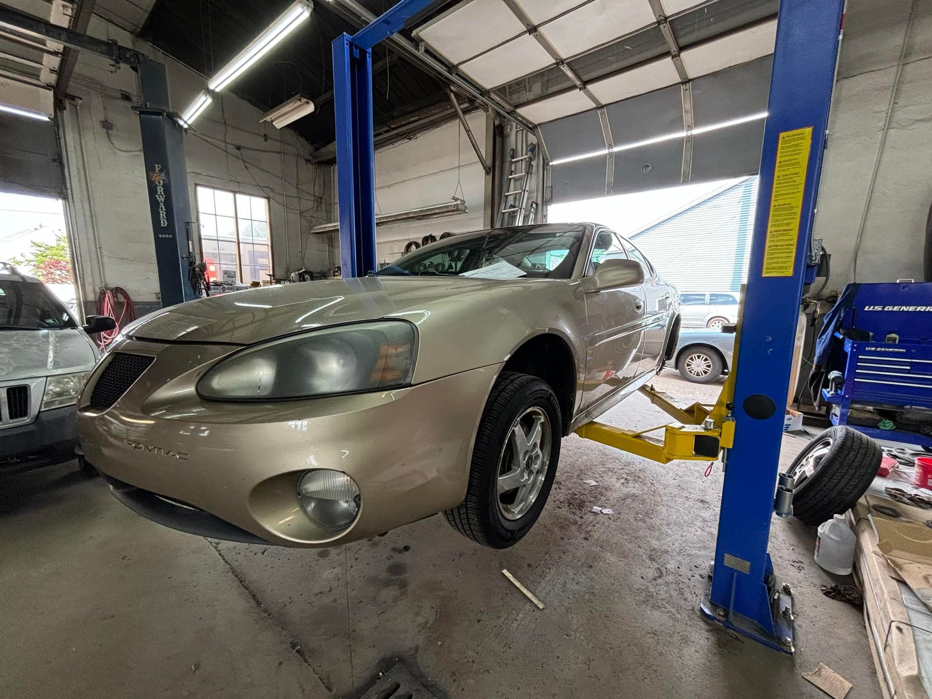A car is sitting on a lift in a garage.