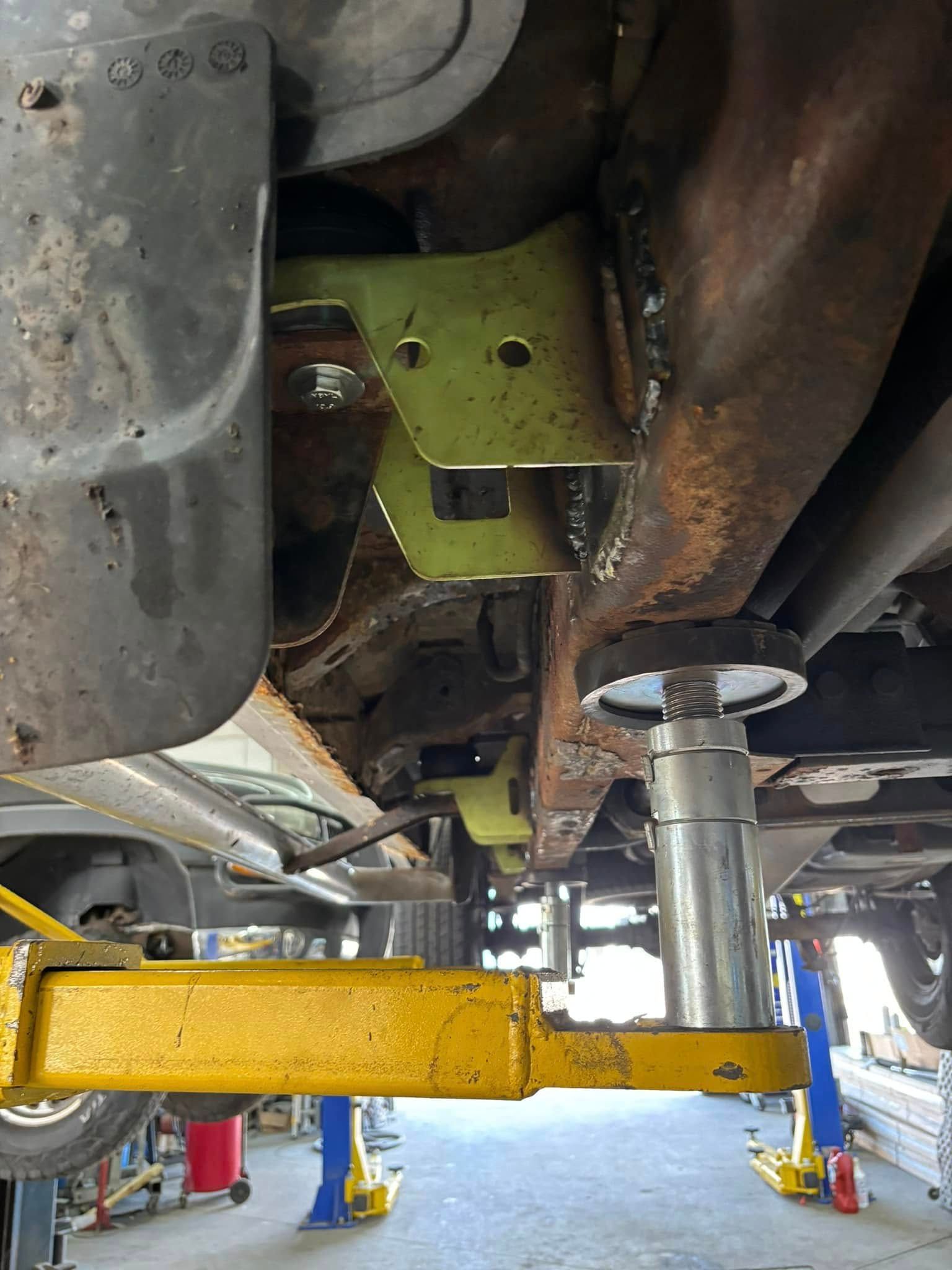 A car is sitting on a lift in a garage.