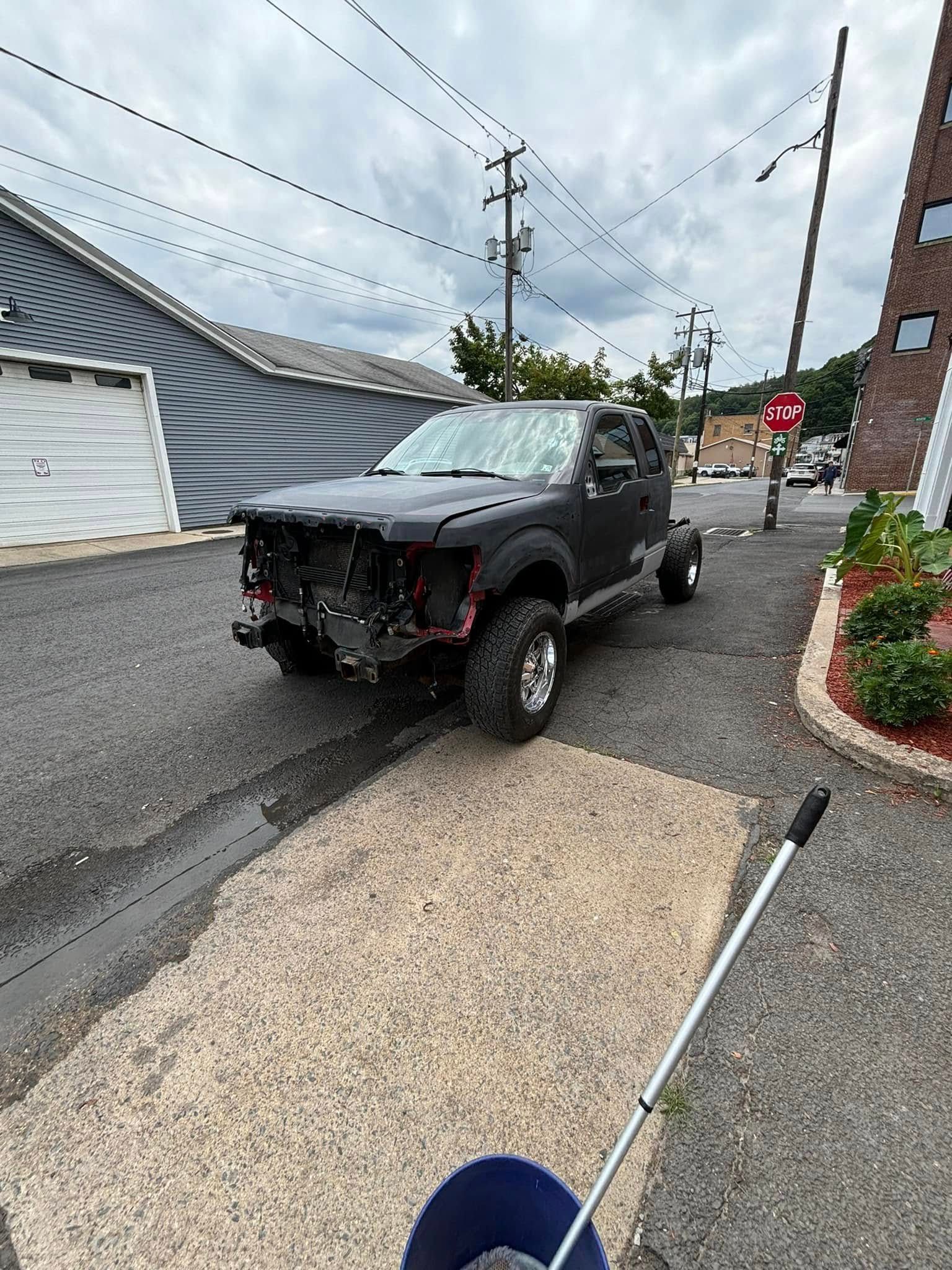 A black truck is parked on the side of the road.