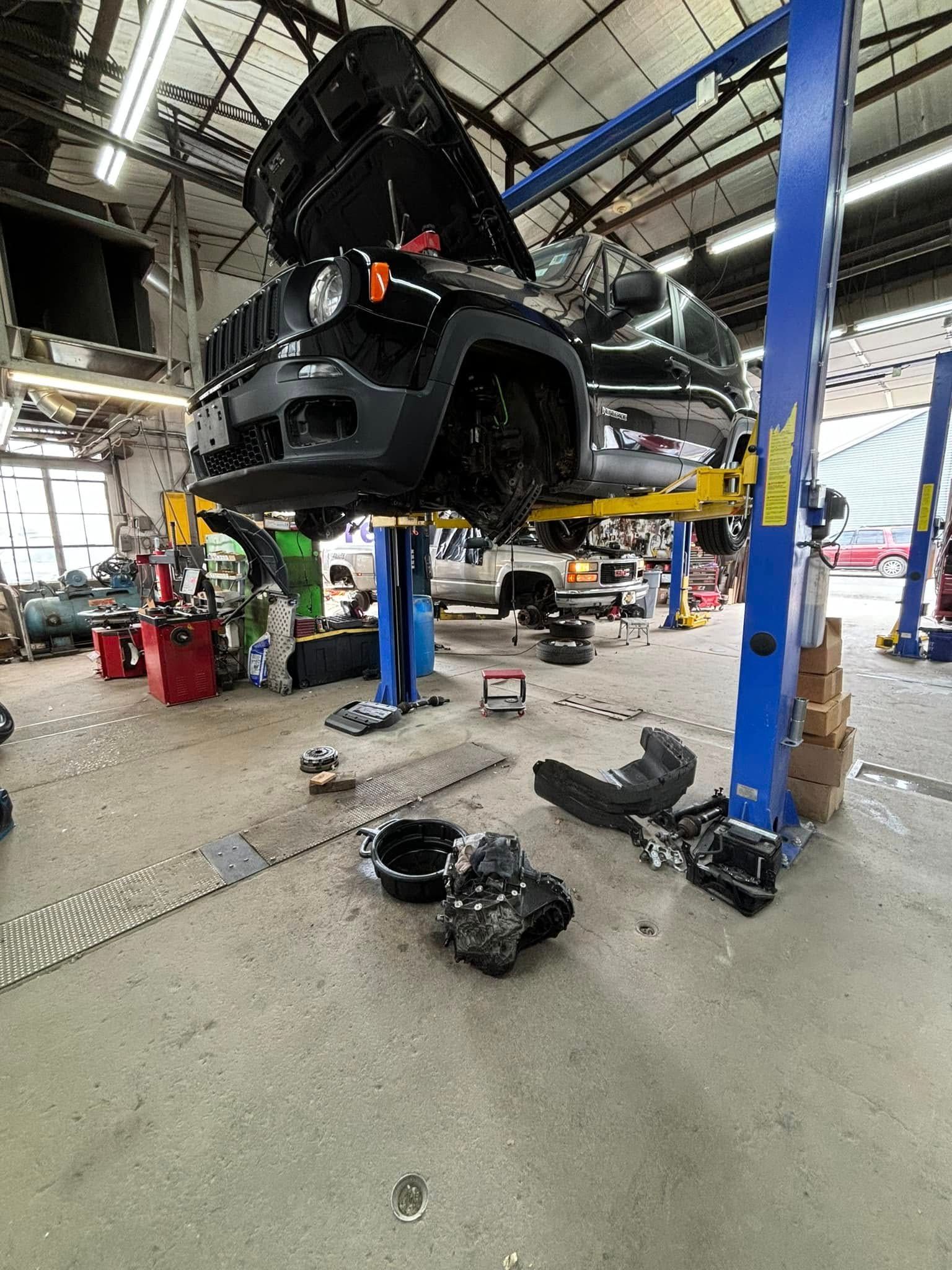 A car is sitting on a lift in a garage.