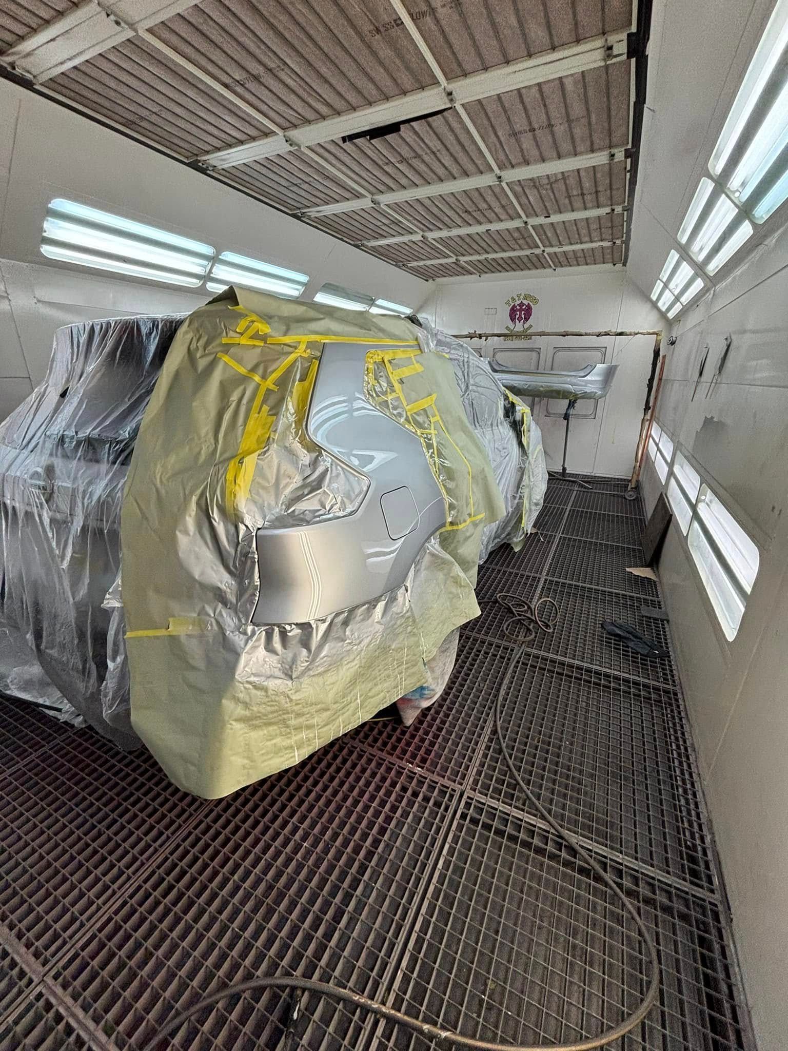 A car is being painted in a paint booth.
