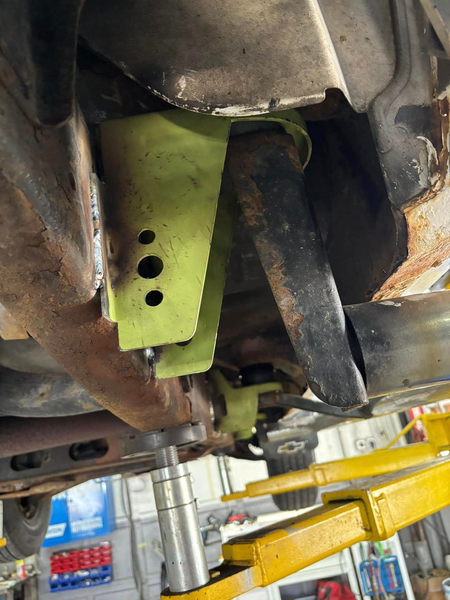 A car is sitting on a lift in a garage.