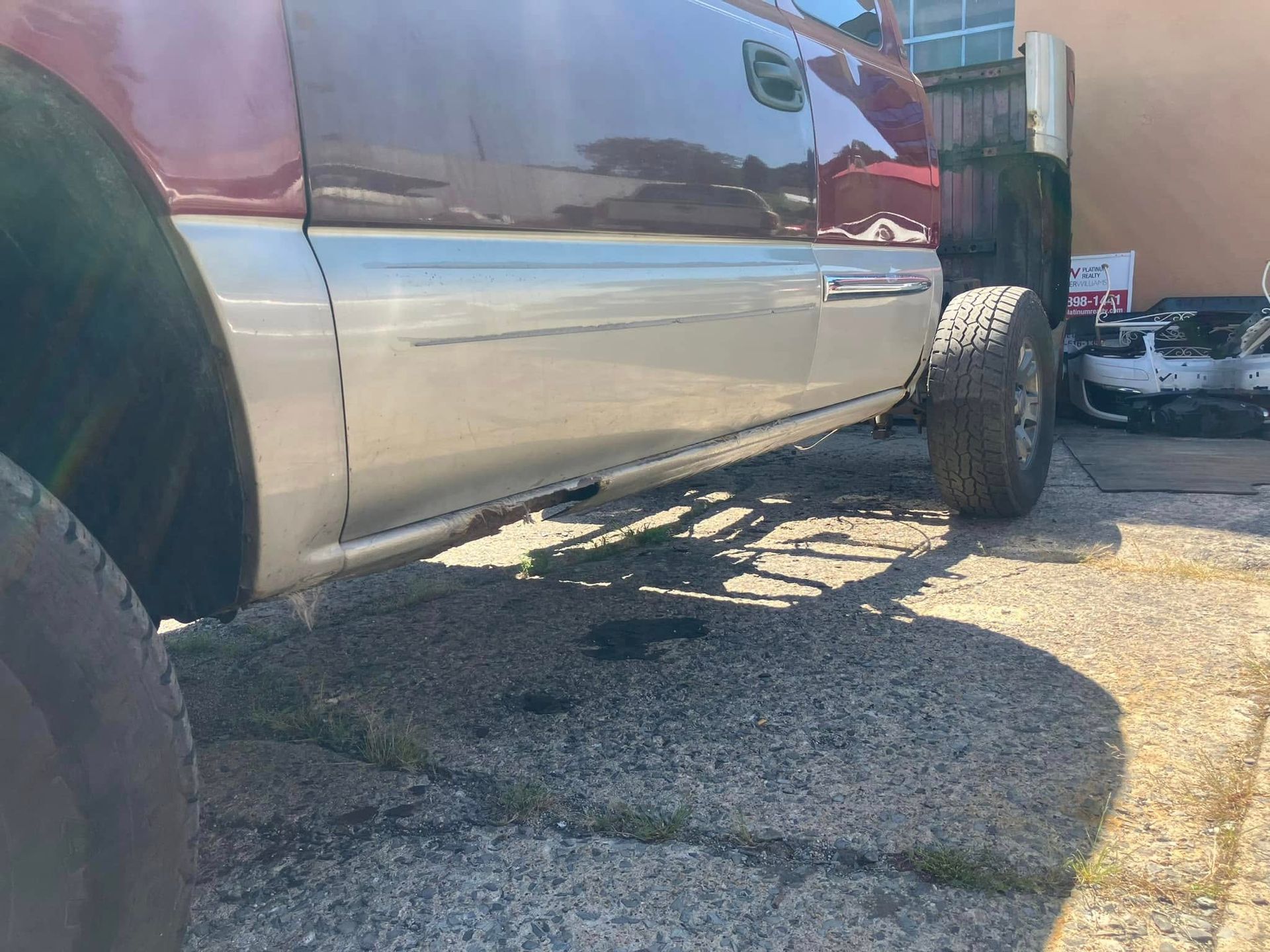 A truck is parked in a parking lot next to a building.