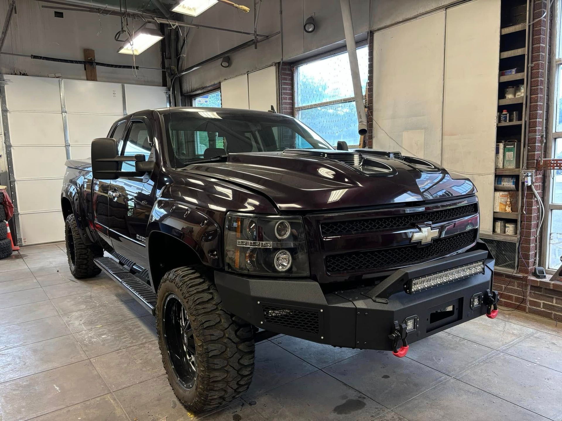 A black truck is parked in a garage.