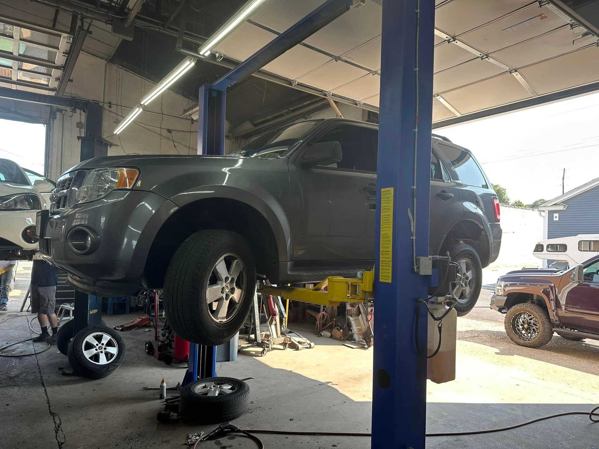 A car is sitting on a lift in a garage.