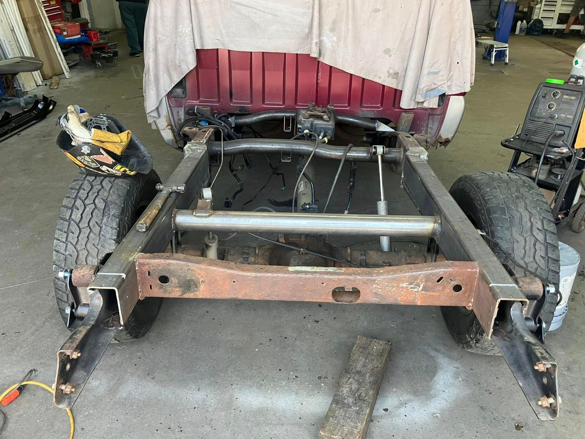 A red truck is being built in a garage.