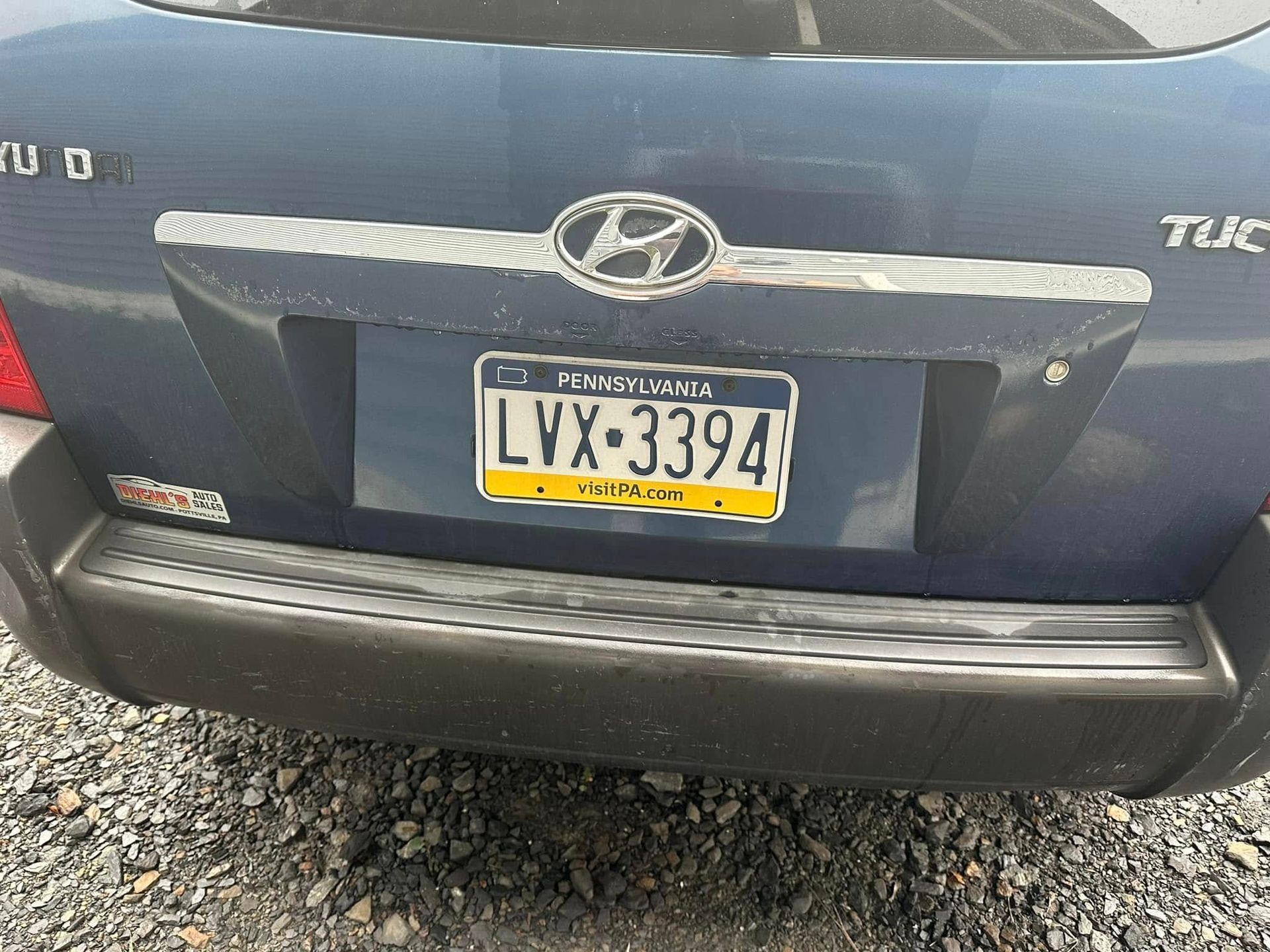 A blue hyundai tuc with a license plate that says lvx 3394