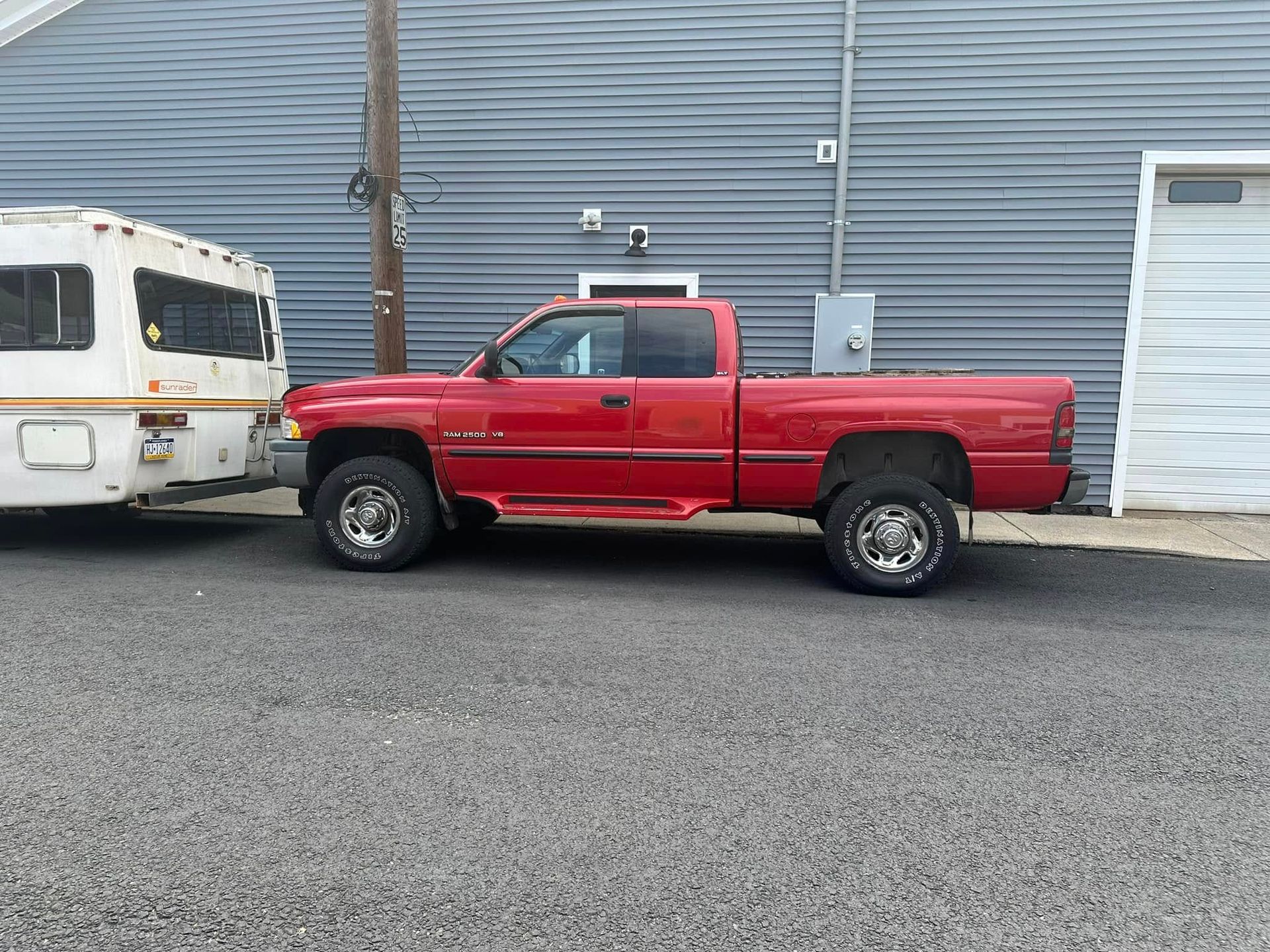 A red truck is parked next to a white trailer.