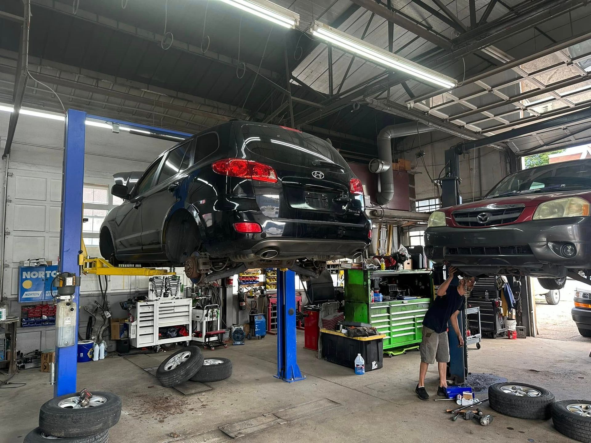 A car is sitting on a lift in a garage.