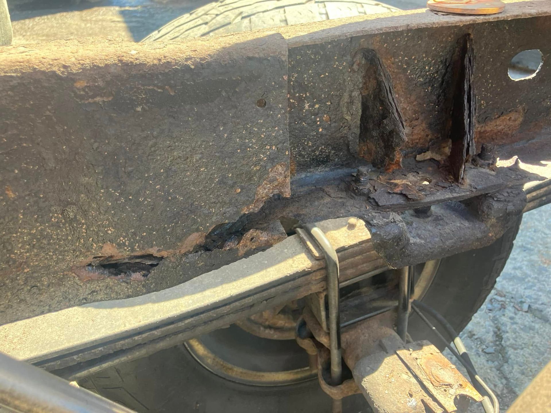 A close up of a rusty metal frame on a truck.