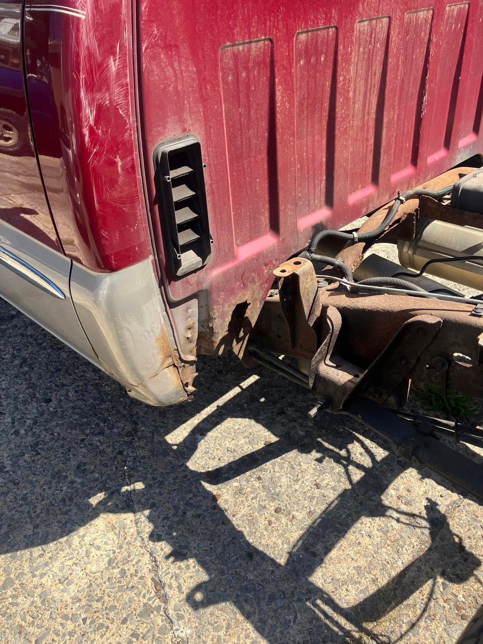 A red truck is parked on the side of the road.