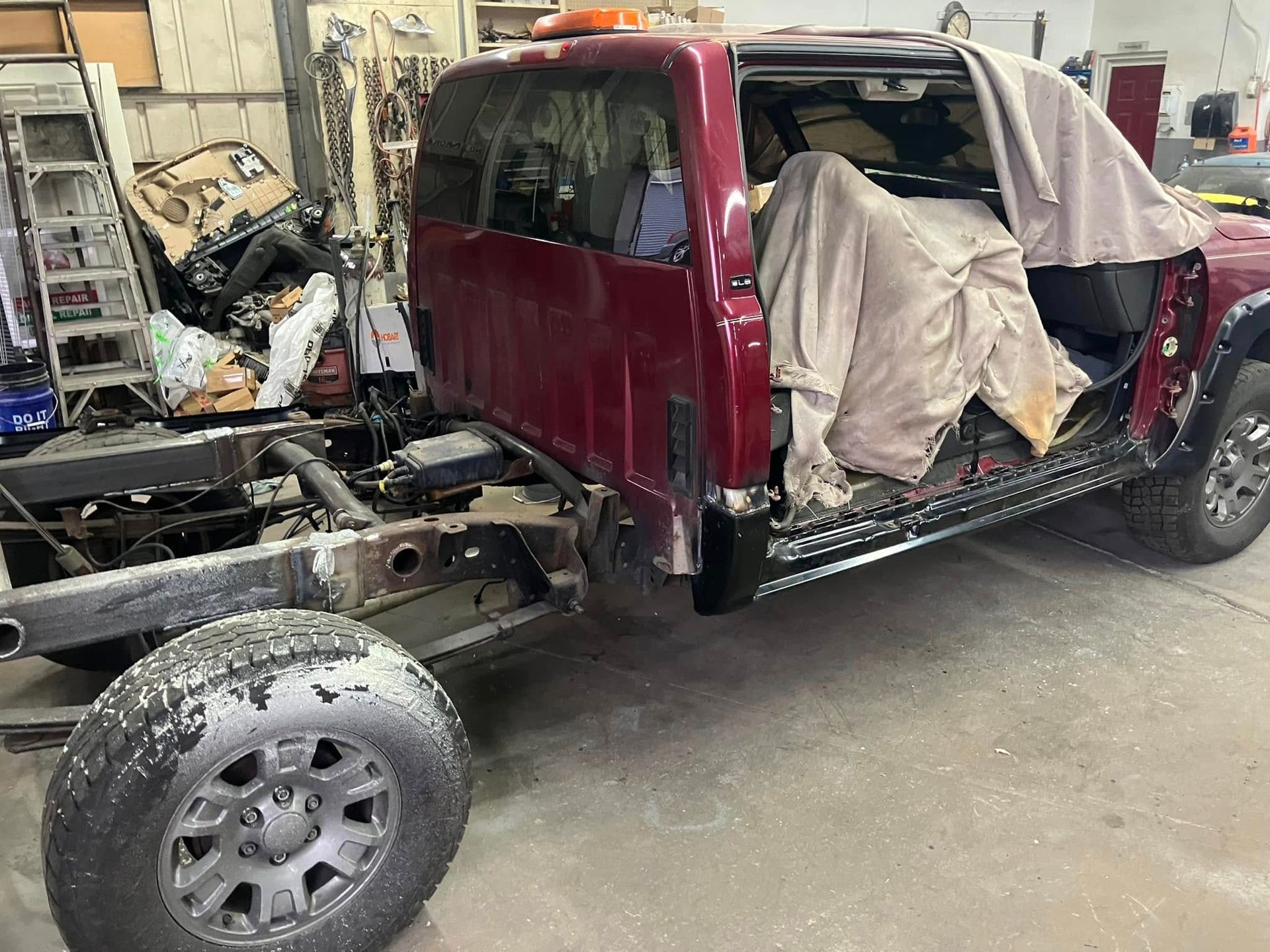 A red truck is being built in a garage.