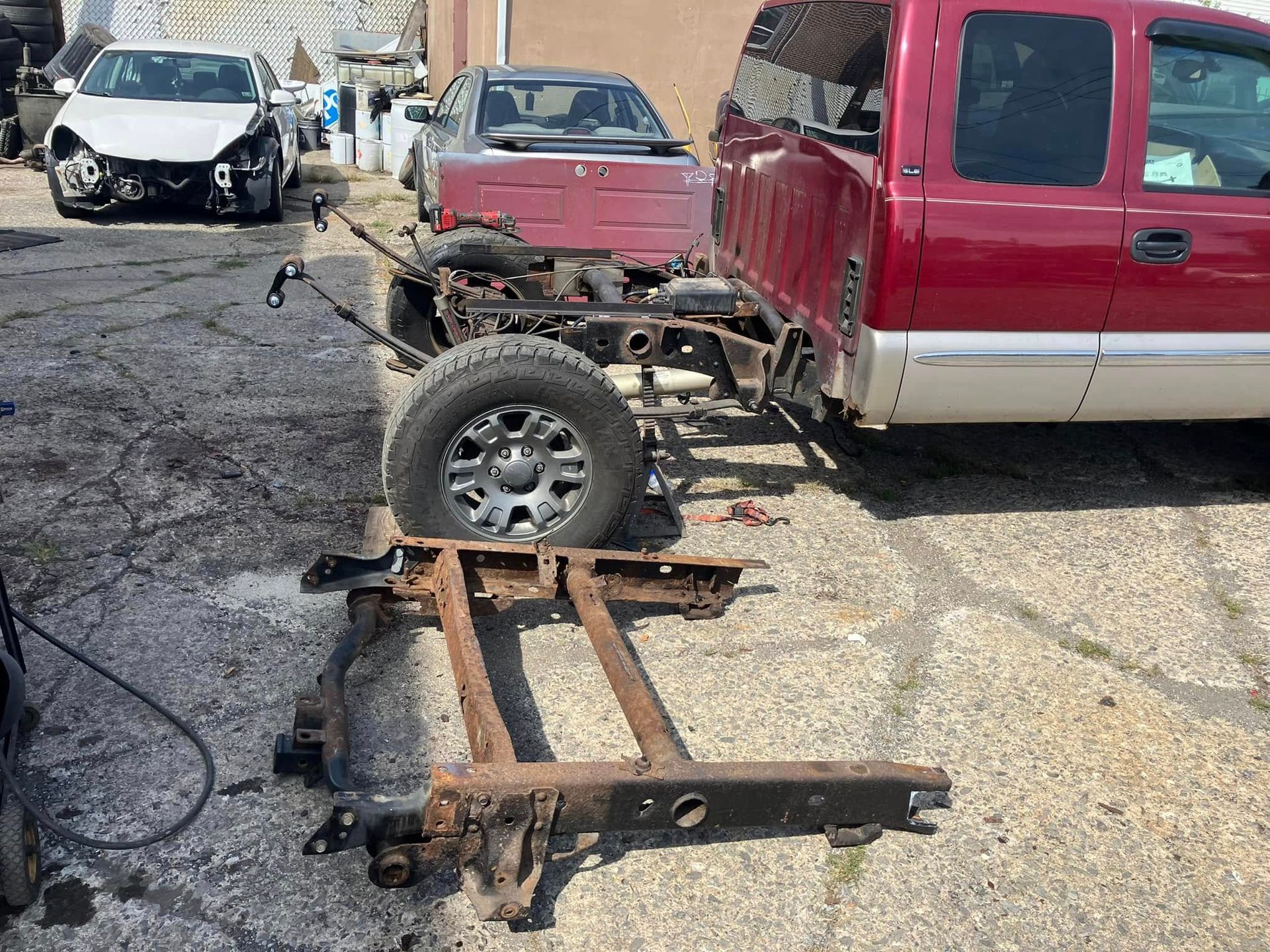 A red truck with a trailer attached to it is parked in a parking lot.