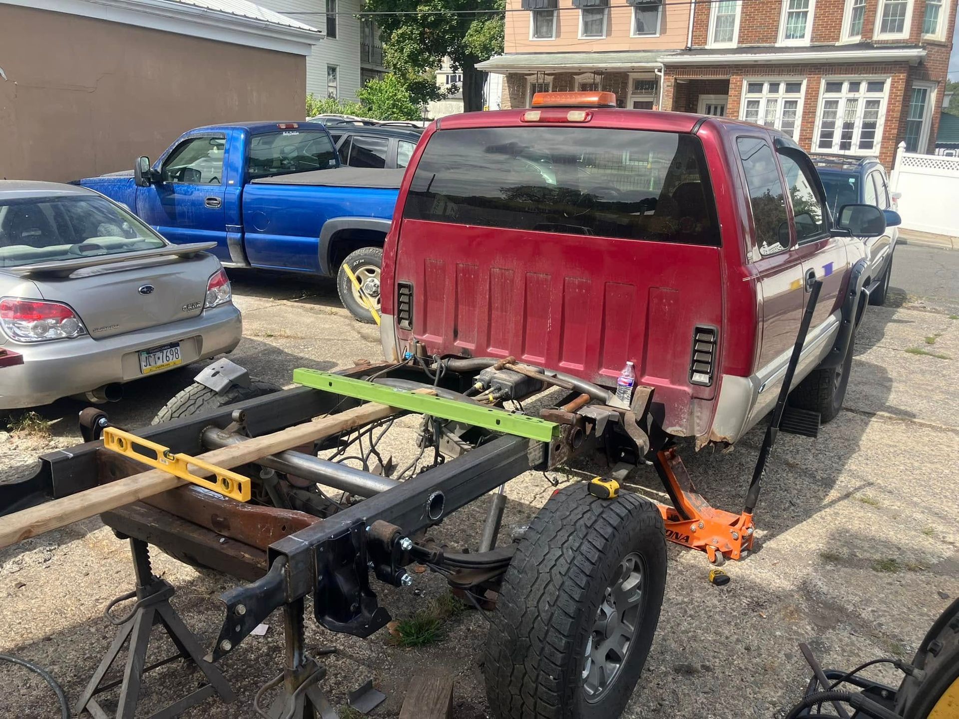 A red truck with a trailer attached to it is parked in a parking lot.