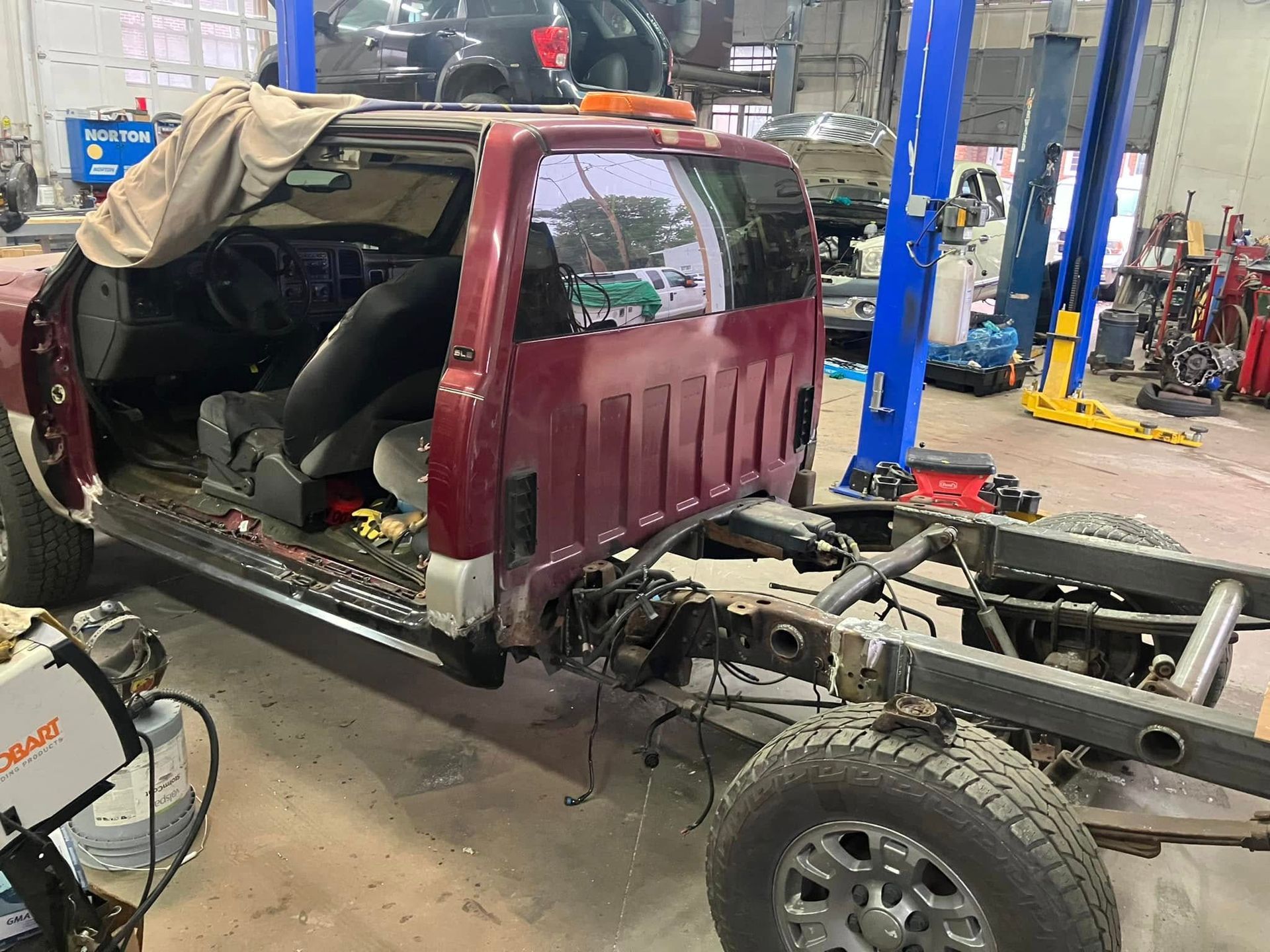 A red truck is being built in a garage.