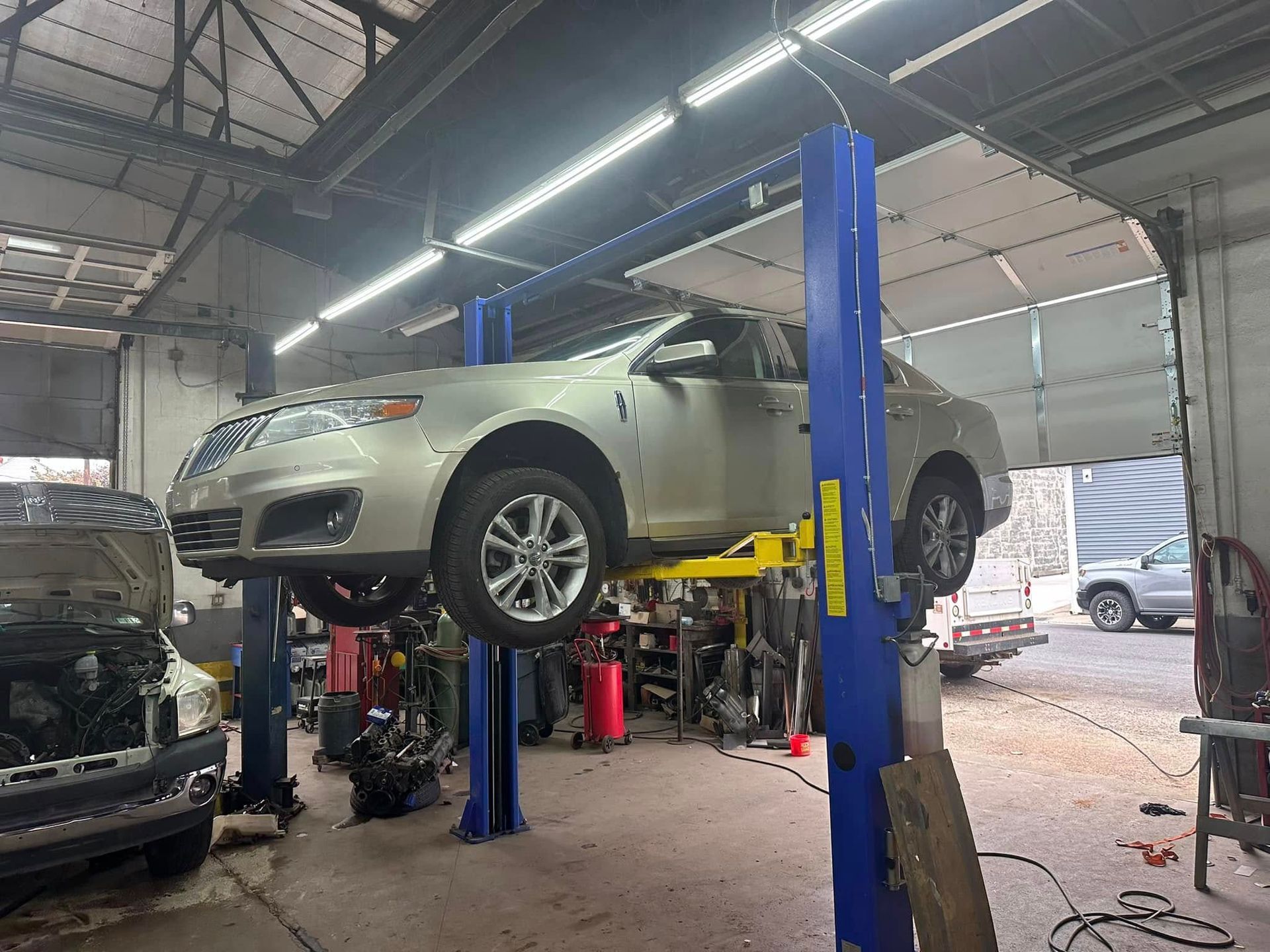 A car is sitting on a lift in a garage.