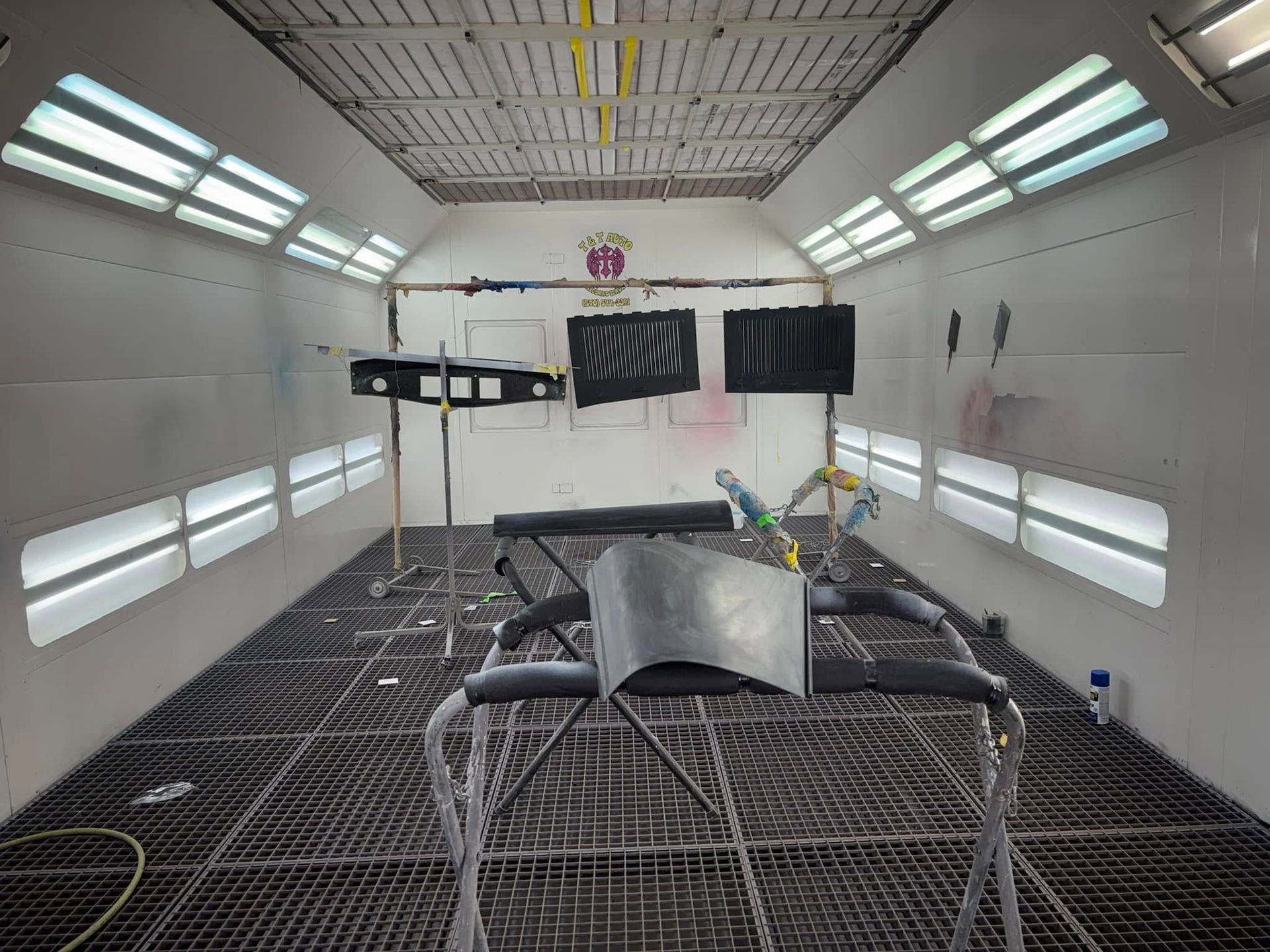 A car is being painted in a paint booth.
