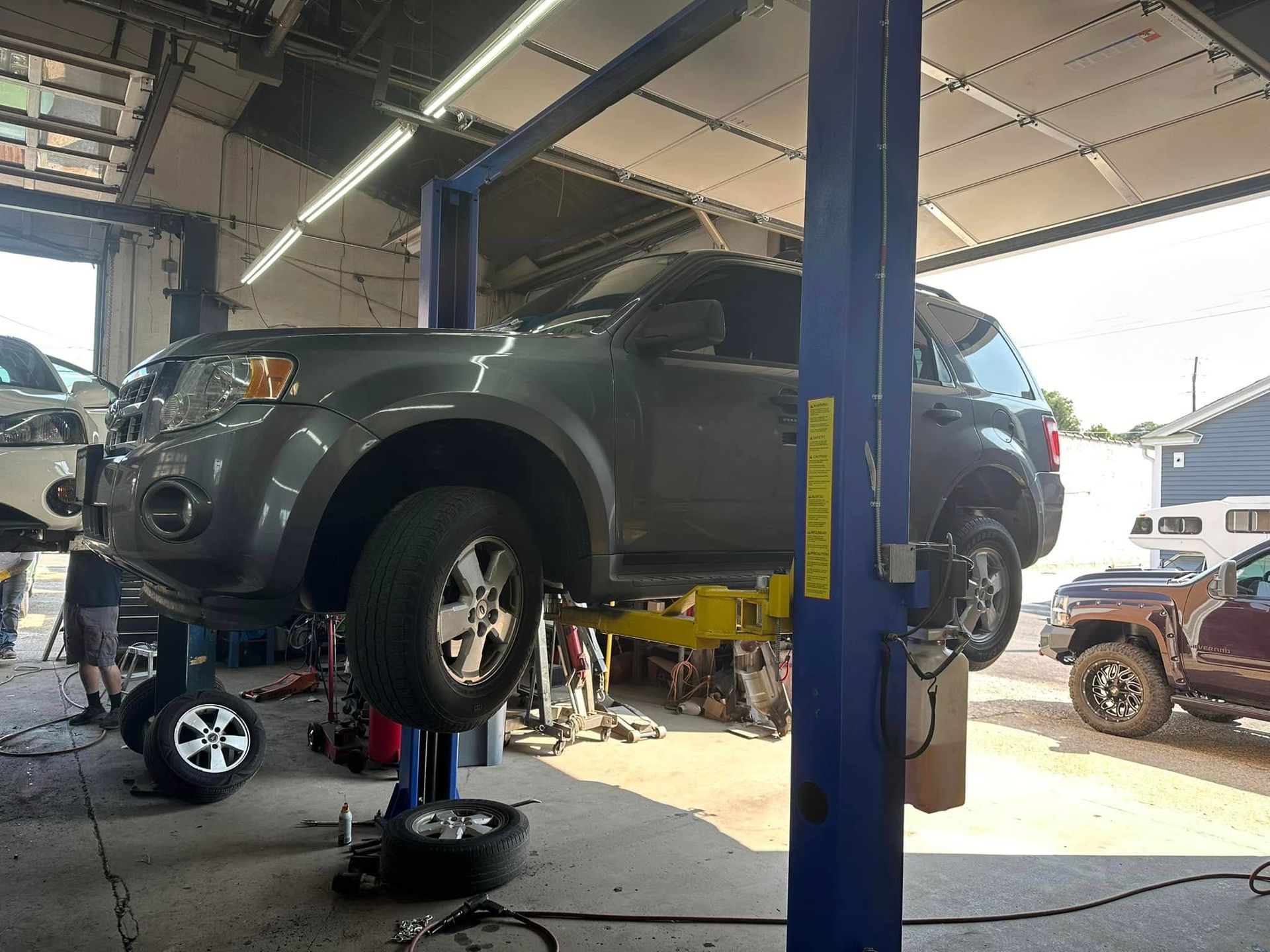 A car is sitting on a lift in a garage.