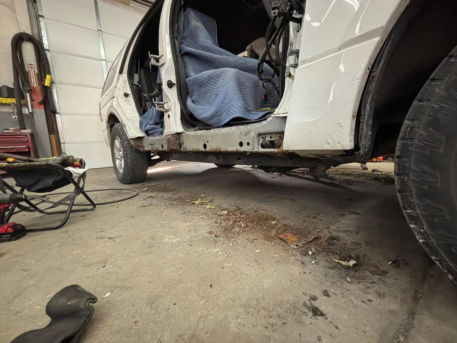 A white van is sitting in a garage with the door open.