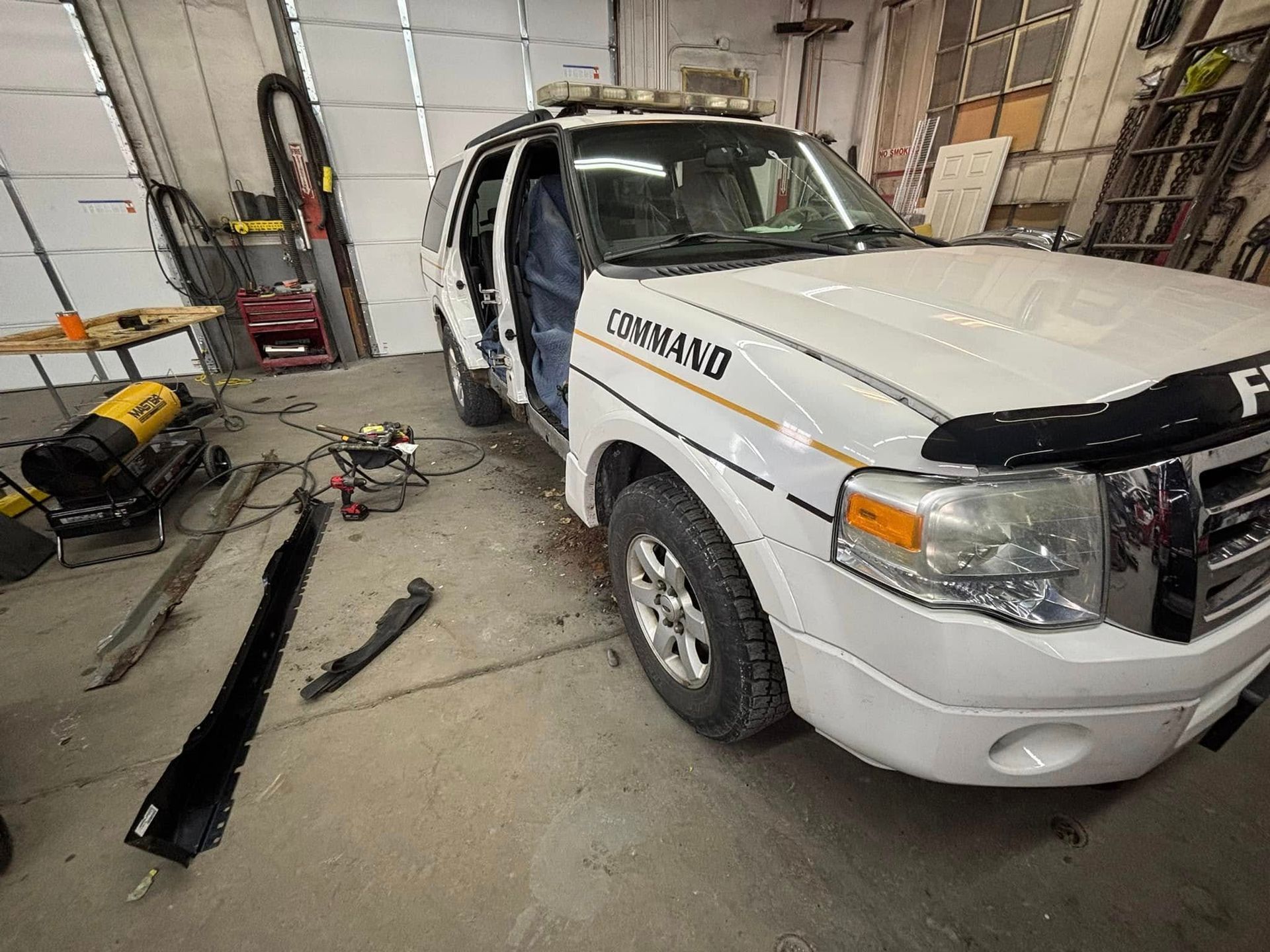 A white command vehicle is parked in a garage.