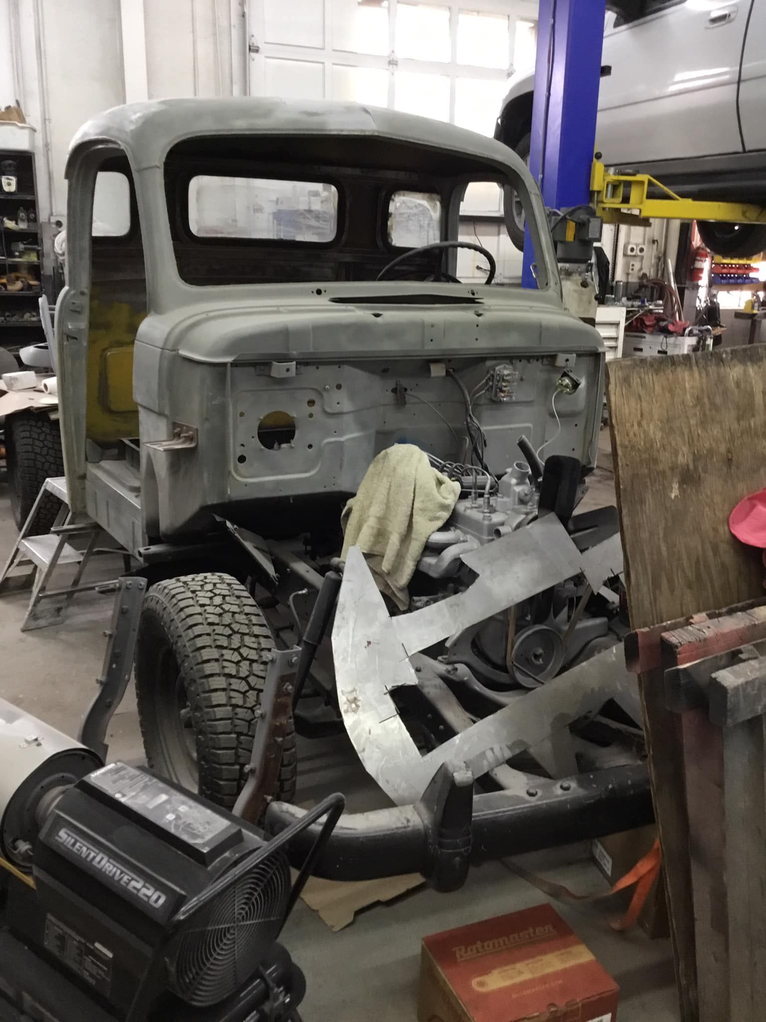An old truck is being restored in a garage.