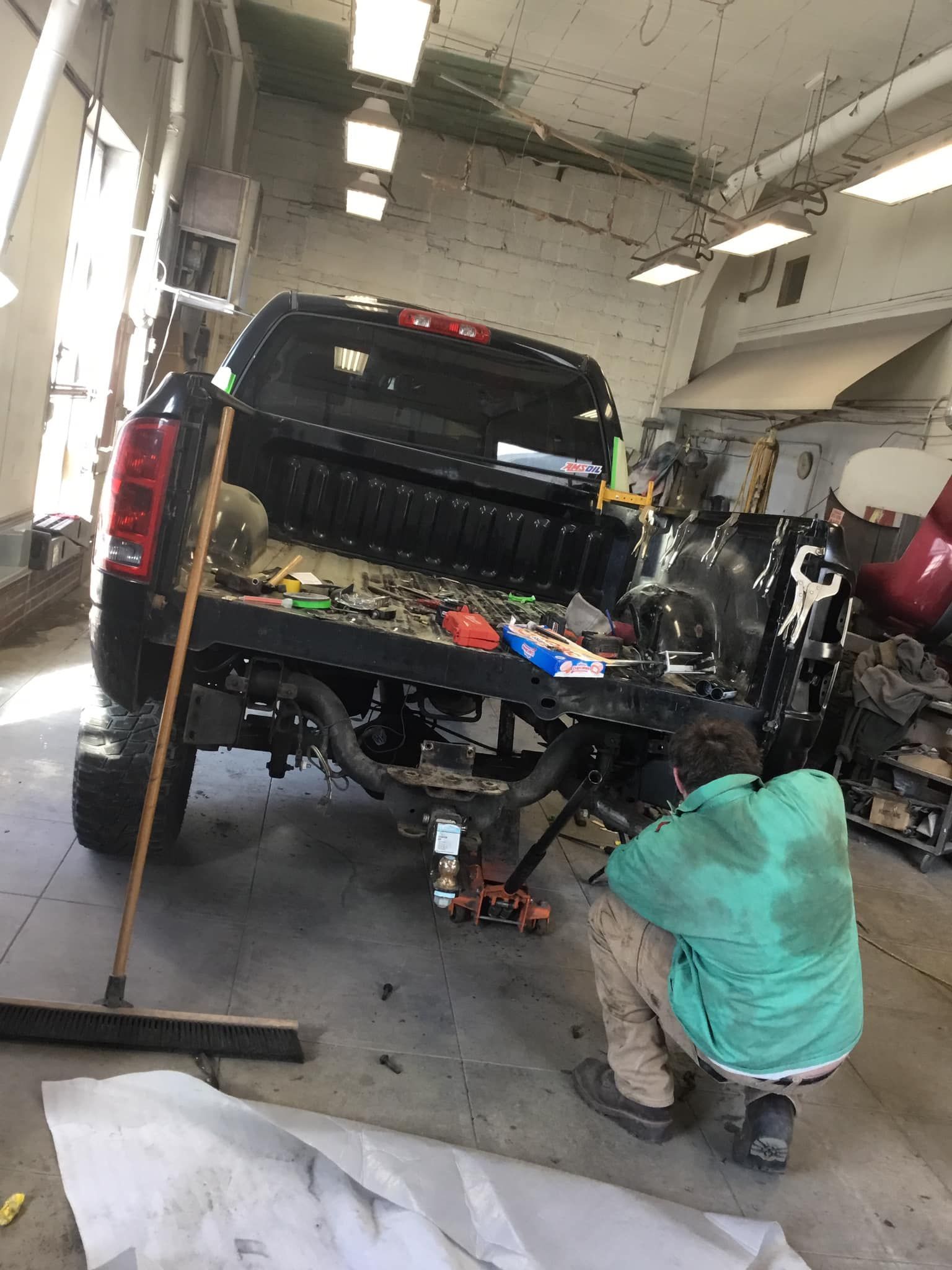 A man is working on a truck in a garage.