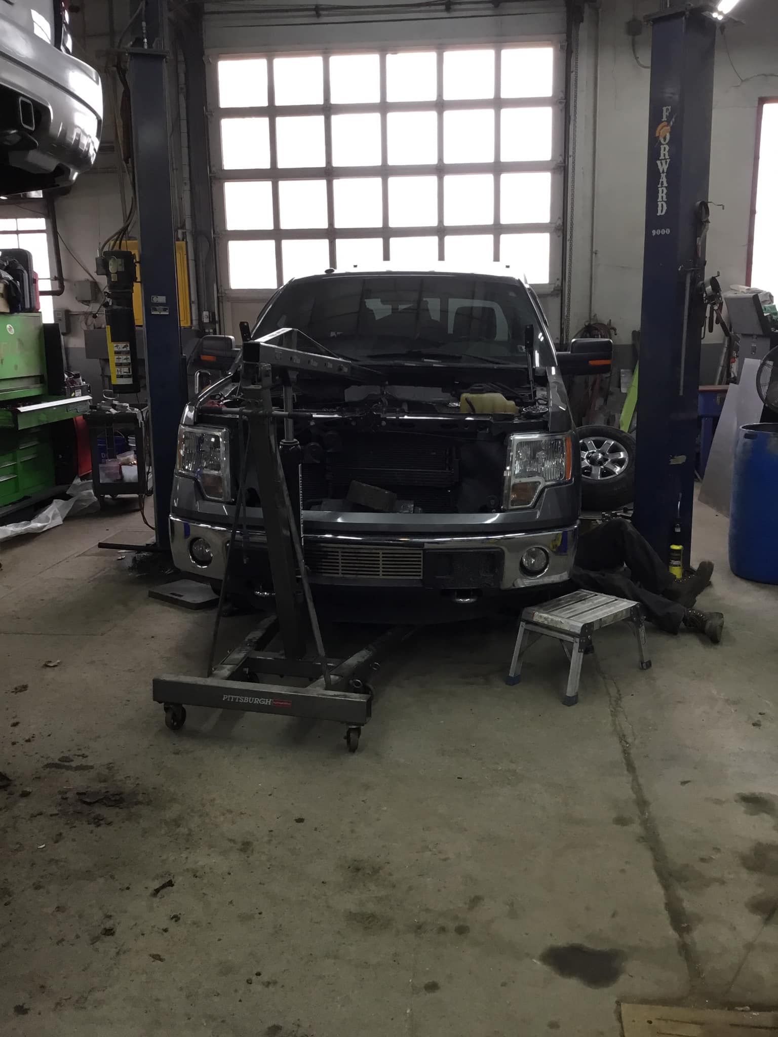 A truck is sitting on a lift in a garage.