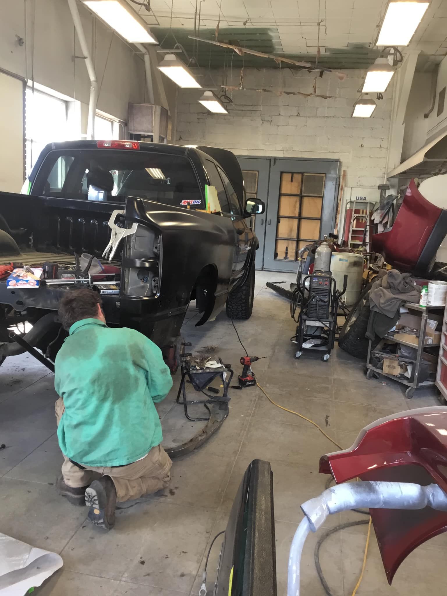A man is working on a truck in a garage.