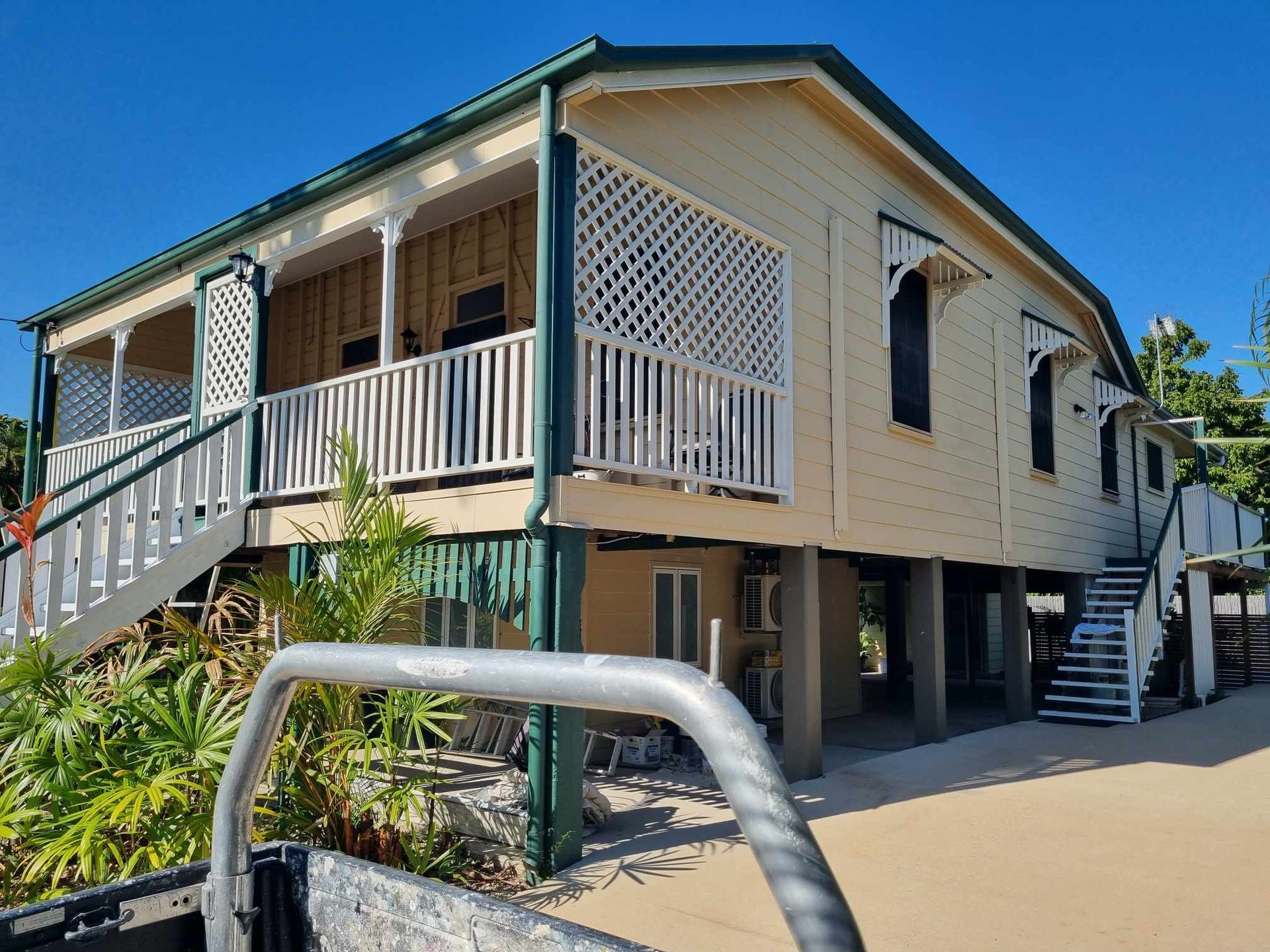Yellow Wooden House on Stilts — Israel Jones Painting in Rowes Bay, QLD