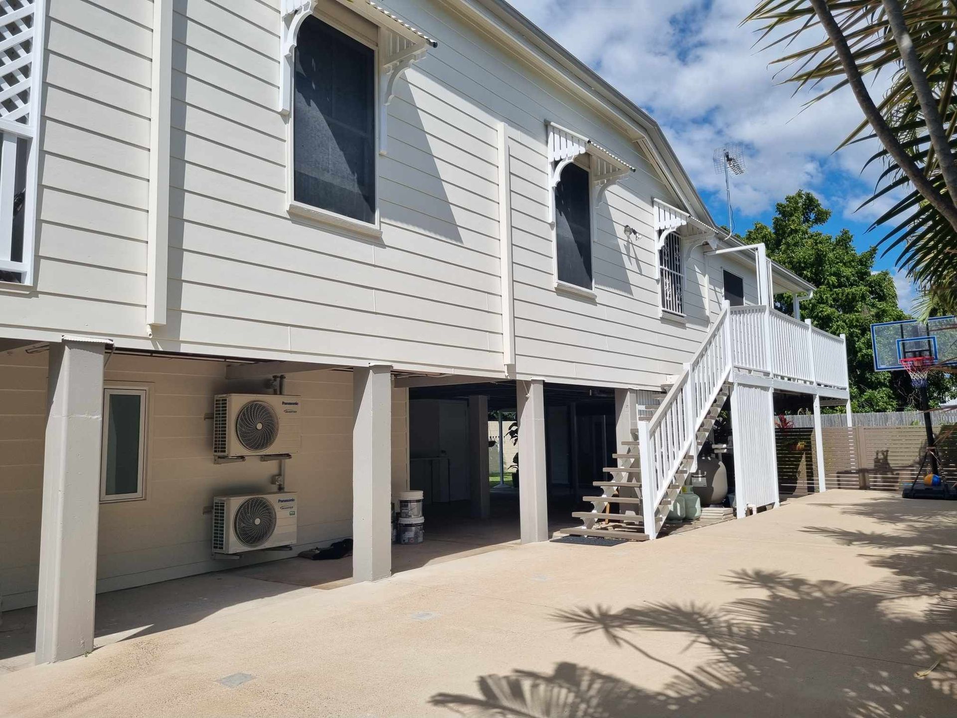 White Two-story House on Stilts With Outdoor Stairs — Israel Jones Painting in Vincent, QLD