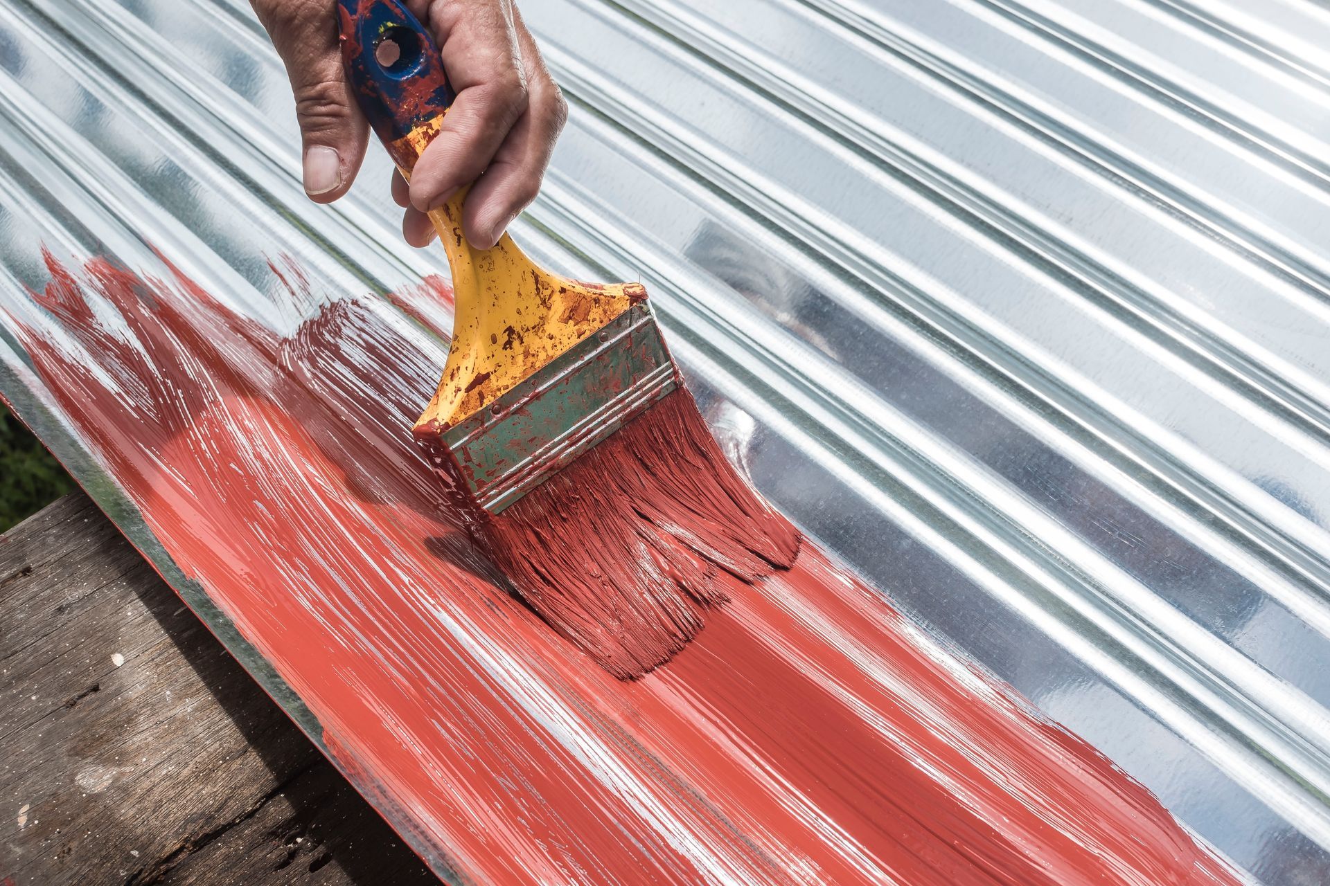 Hand Painting Red Paint Onto Corrugated Metal — Israel Jones Painting in Vincent, QLD