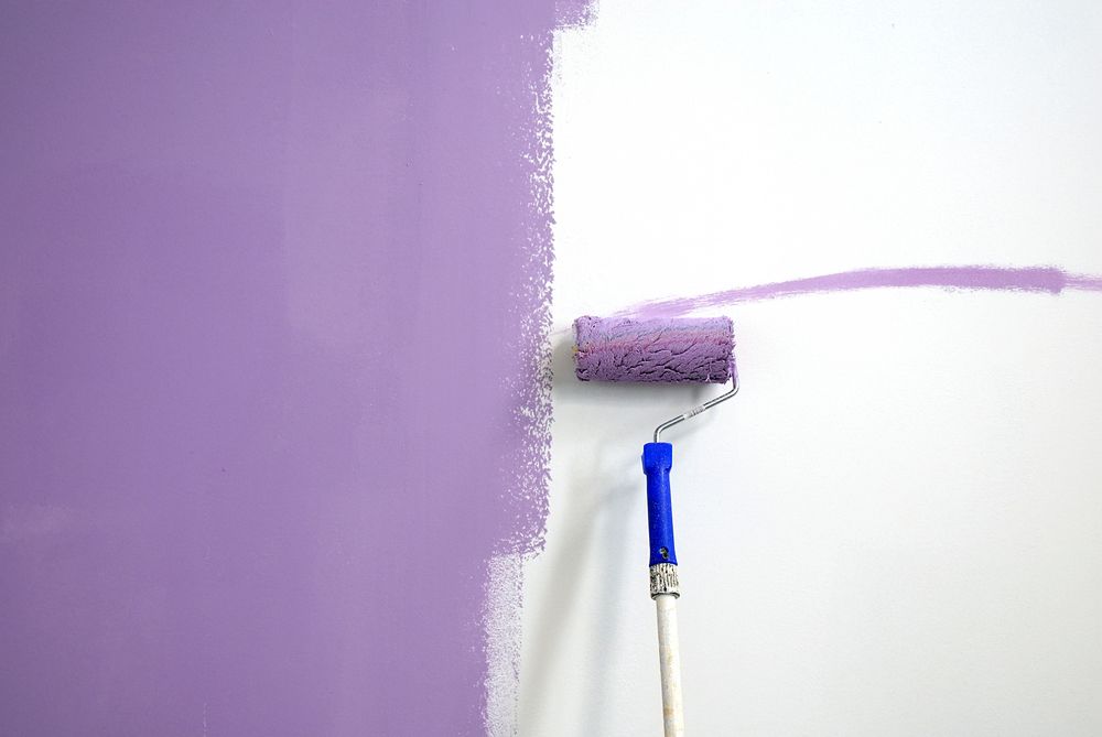 Paint Roller Applying Lavender Paint to a White Wall — Israel Jones Painting in Rowes Bay, QLD