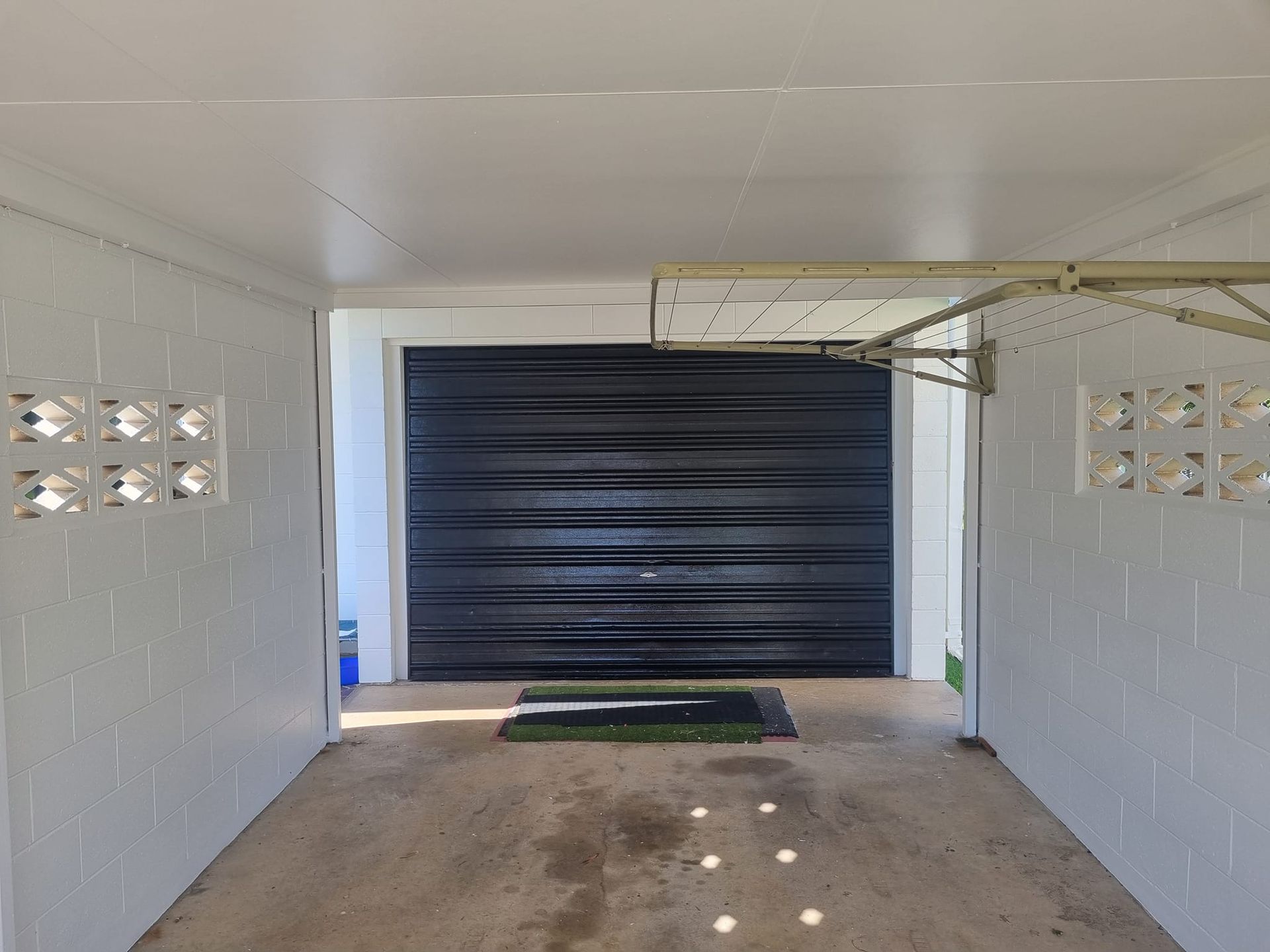 White Carport With a Closed Black Garage Door — Israel Jones Painting in Vincent, QLD