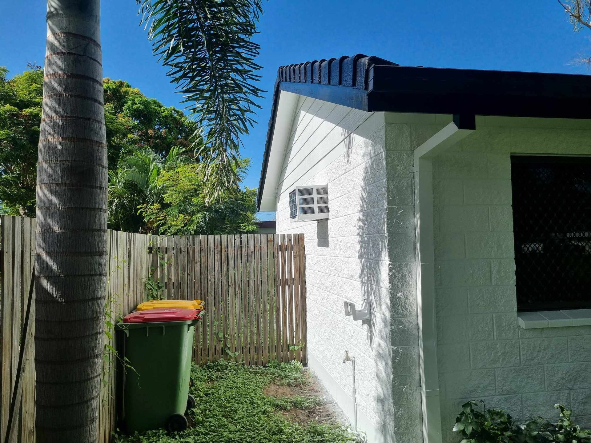 White Building With Dark Roof Next to Wooden Fence — Israel Jones Painting in Vincent, QLD