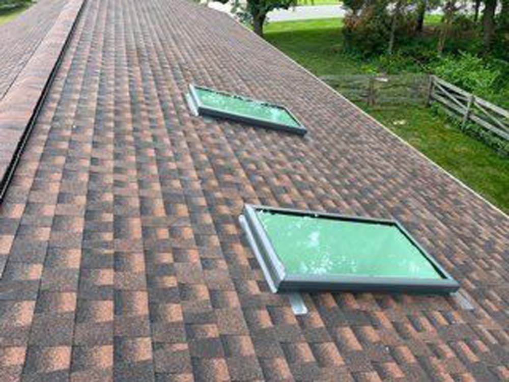 There are two skylights on the roof of a house.
