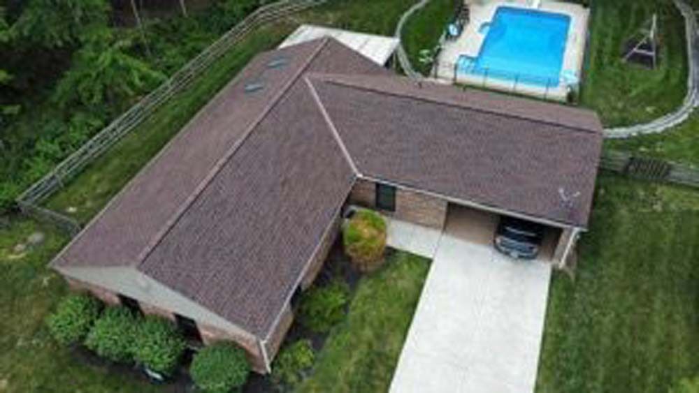 An aerial view of a house with a pool in the backyard.