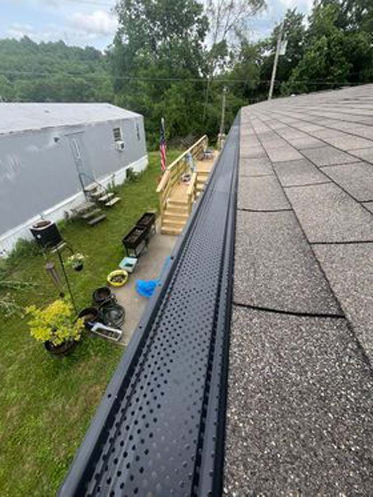There is a gutter on the roof of a house.
