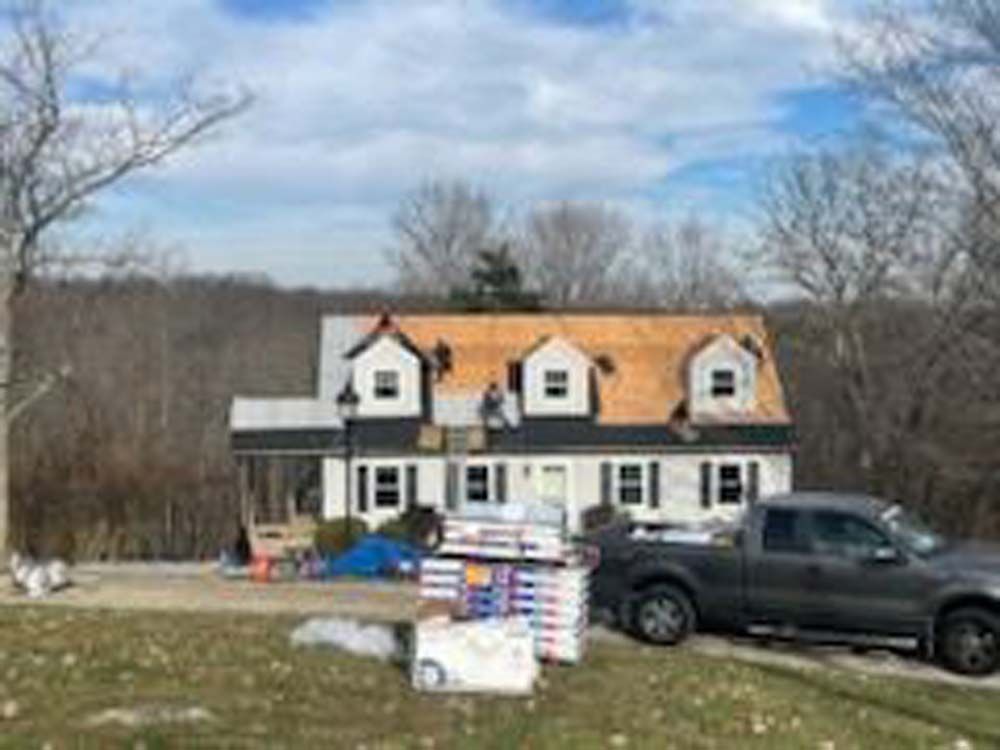 A truck is parked in front of a house under construction.