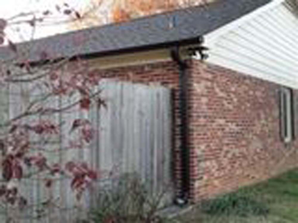 A brick house with a wooden fence in front of it.