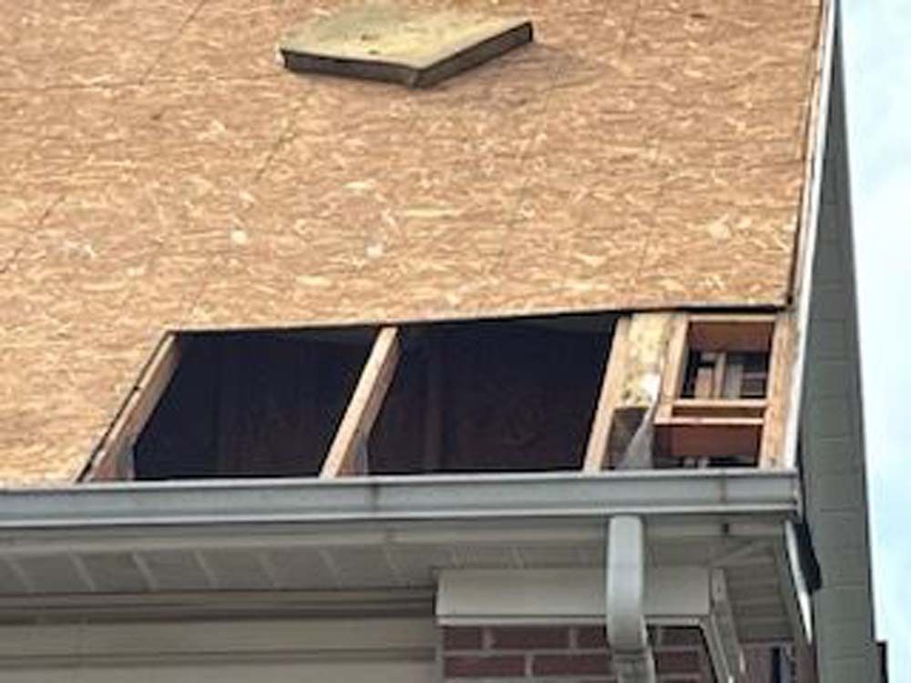 There is a hole in the roof of a house.