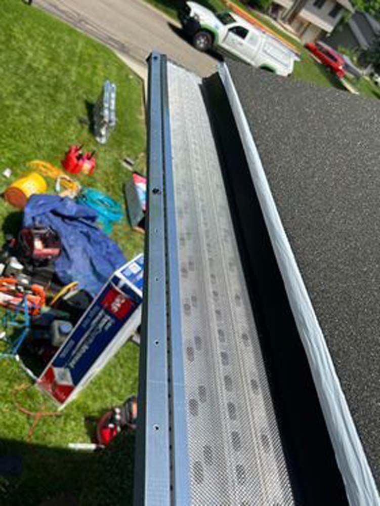 A gutter is being installed on the roof of a house.