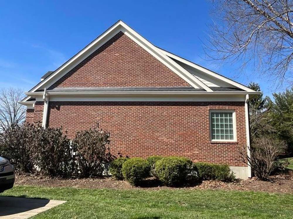 A brick house with a car parked in front of it.