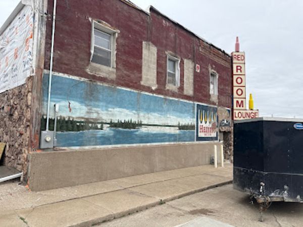 Exterior of the Red Room Lounge, a weathered brick building with a mural of a lake scene.