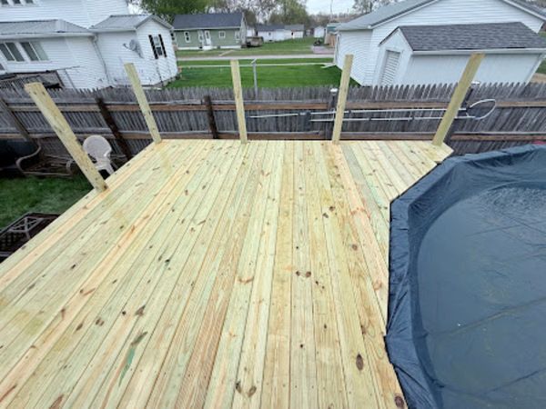 Newly built wooden deck with supporting posts, backyard setting.