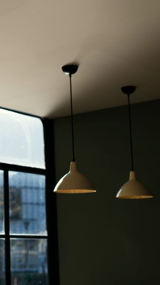 Two pendant lights hanging from the ceiling in front of a window