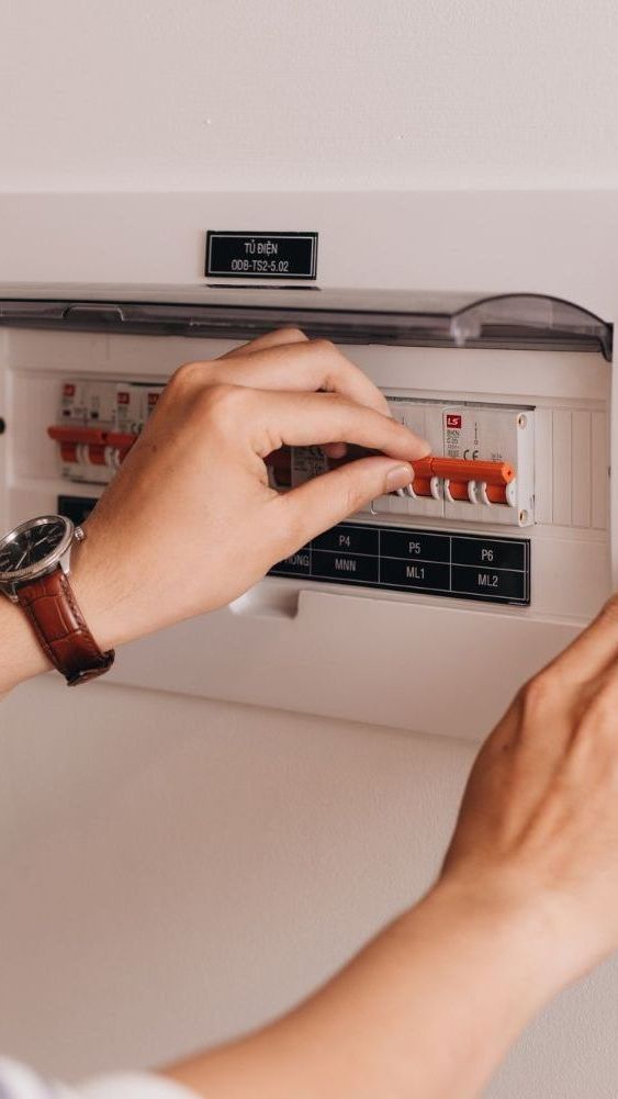 A person is holding a circuit breaker in their hand.