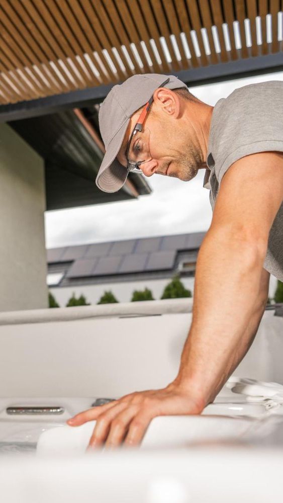 A man wearing a hat and glasses is working on a kitchen counter.