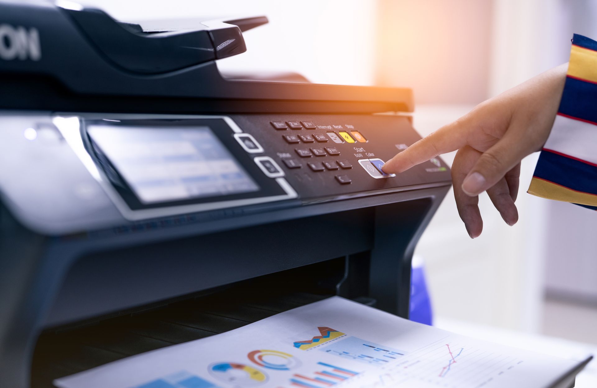 Office worker using multifunction laser printer, showcasing reliable copier repair service.