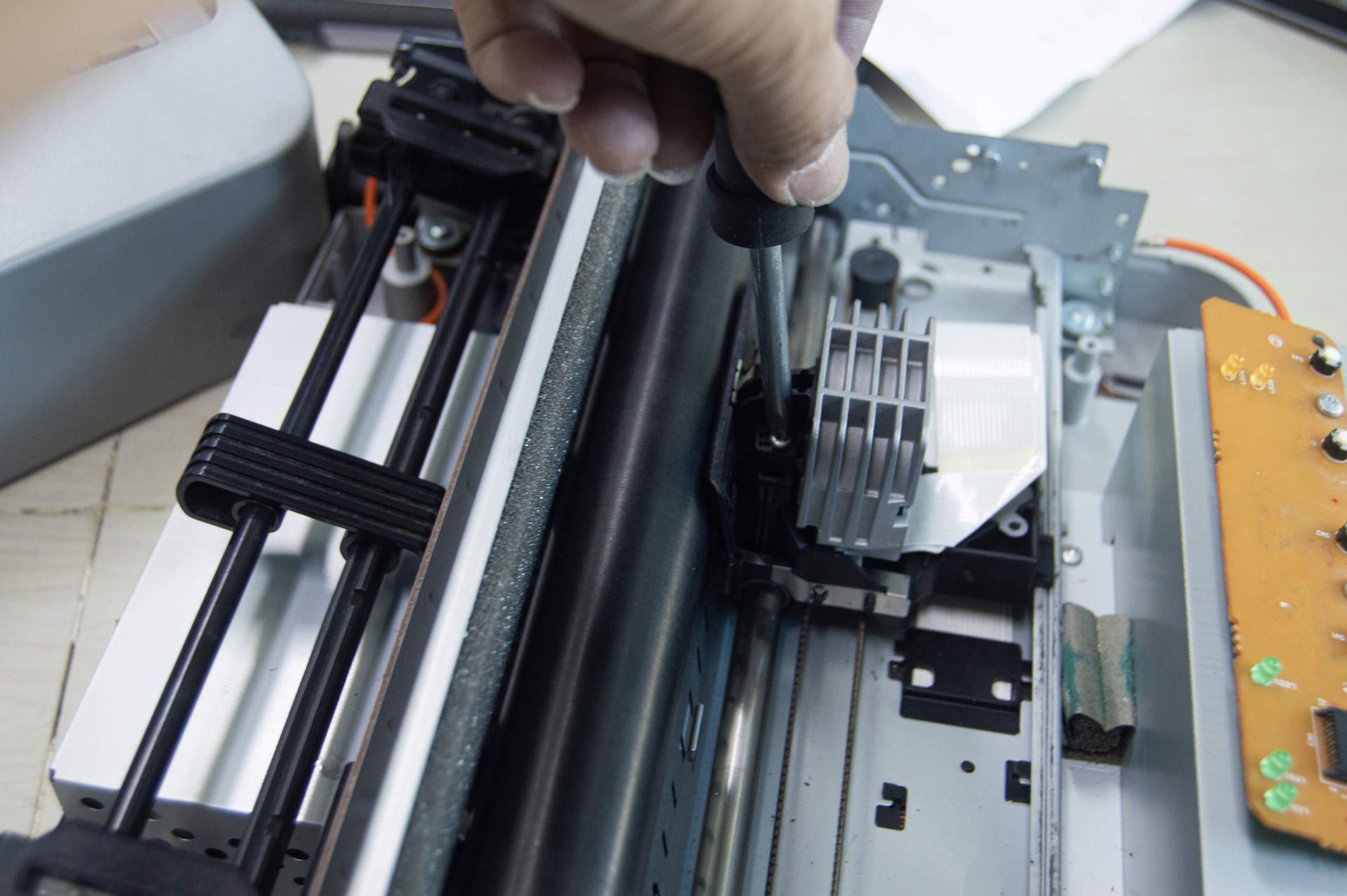 Top view of unrecognized technician inspecting and providing copier repair service.