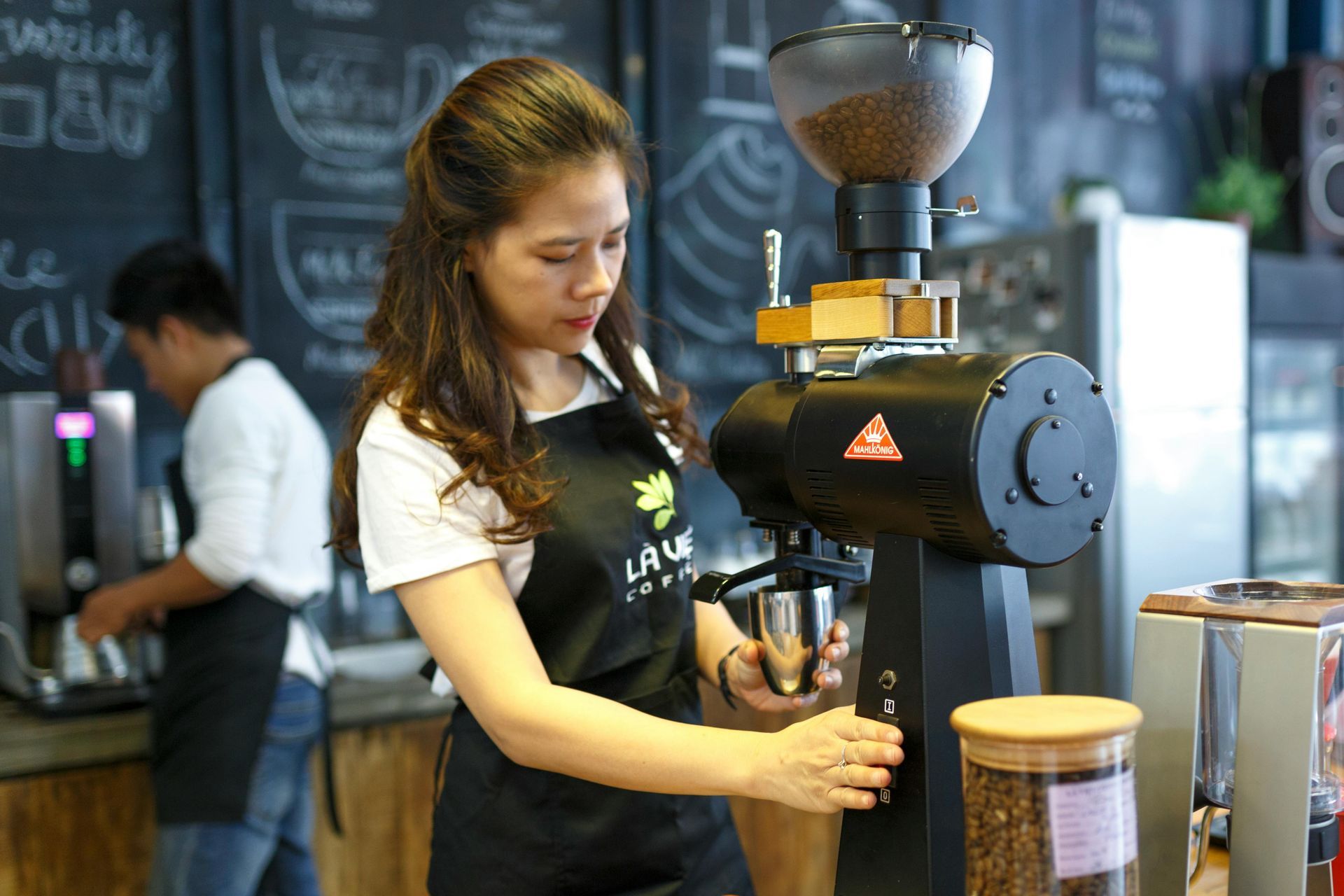 A barista grinding coffee beans.